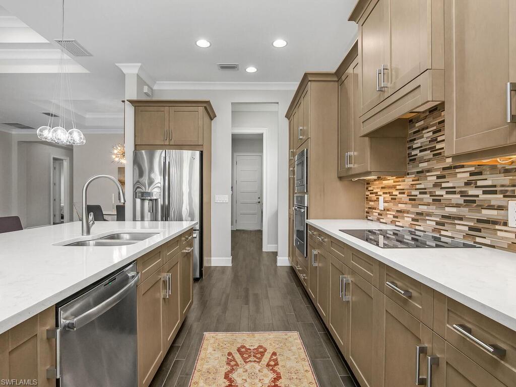 6478 Warwick Avenue Naples, FL 34113 - Photo 20 of 47 a kitchen with stainless steel appliances granite countertop a sink a stove and a refrigerator