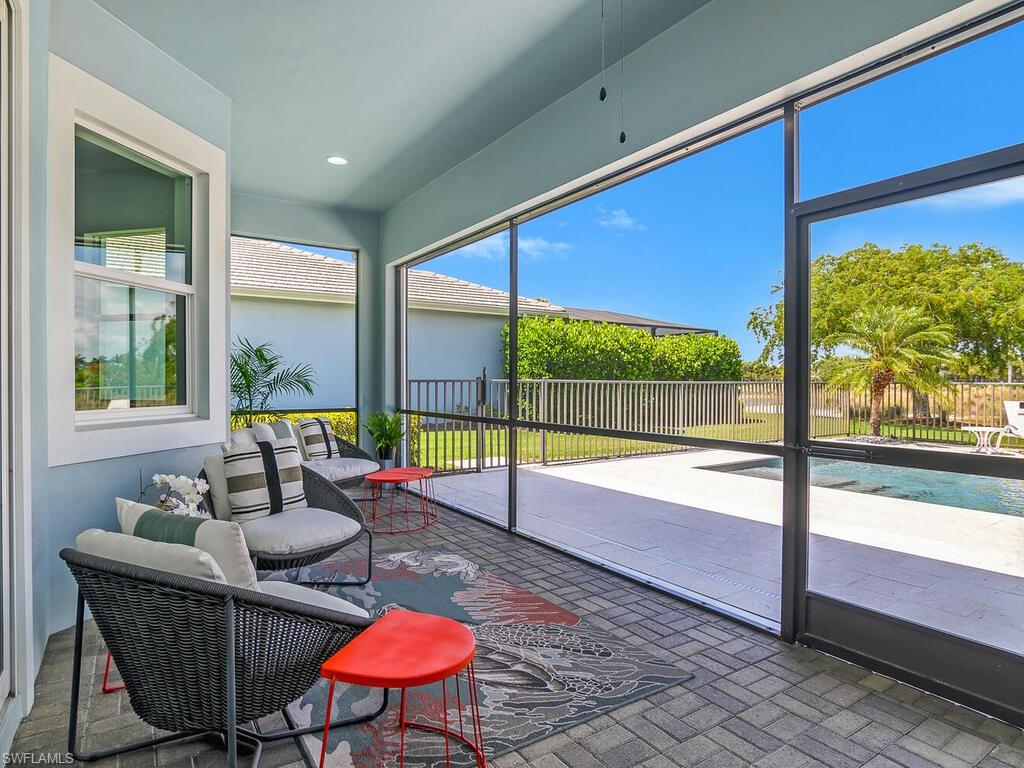 6478 Warwick Avenue Naples, FL 34113 - Photo 22 of 47 a living room with blue floor to ceiling window and a table