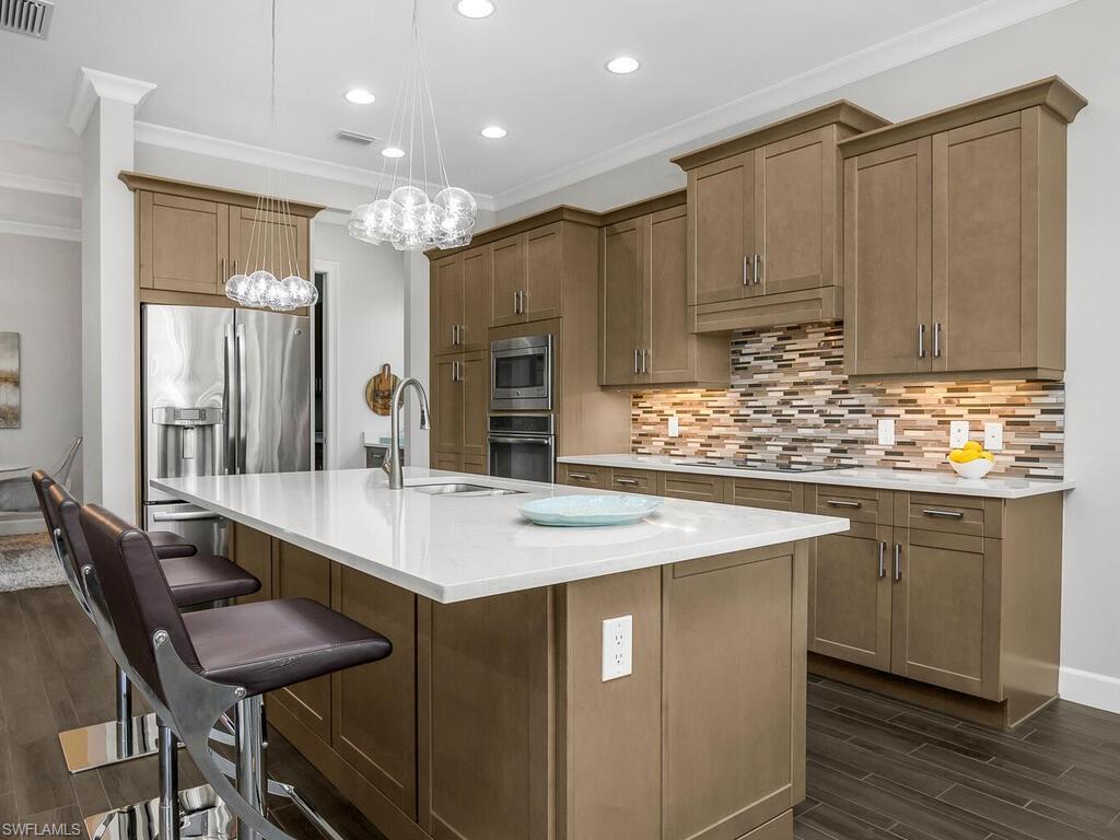 6478 Warwick Avenue Naples, FL 34113 - Photo 4 of 47 a kitchen with kitchen island granite countertop a sink and cabinets