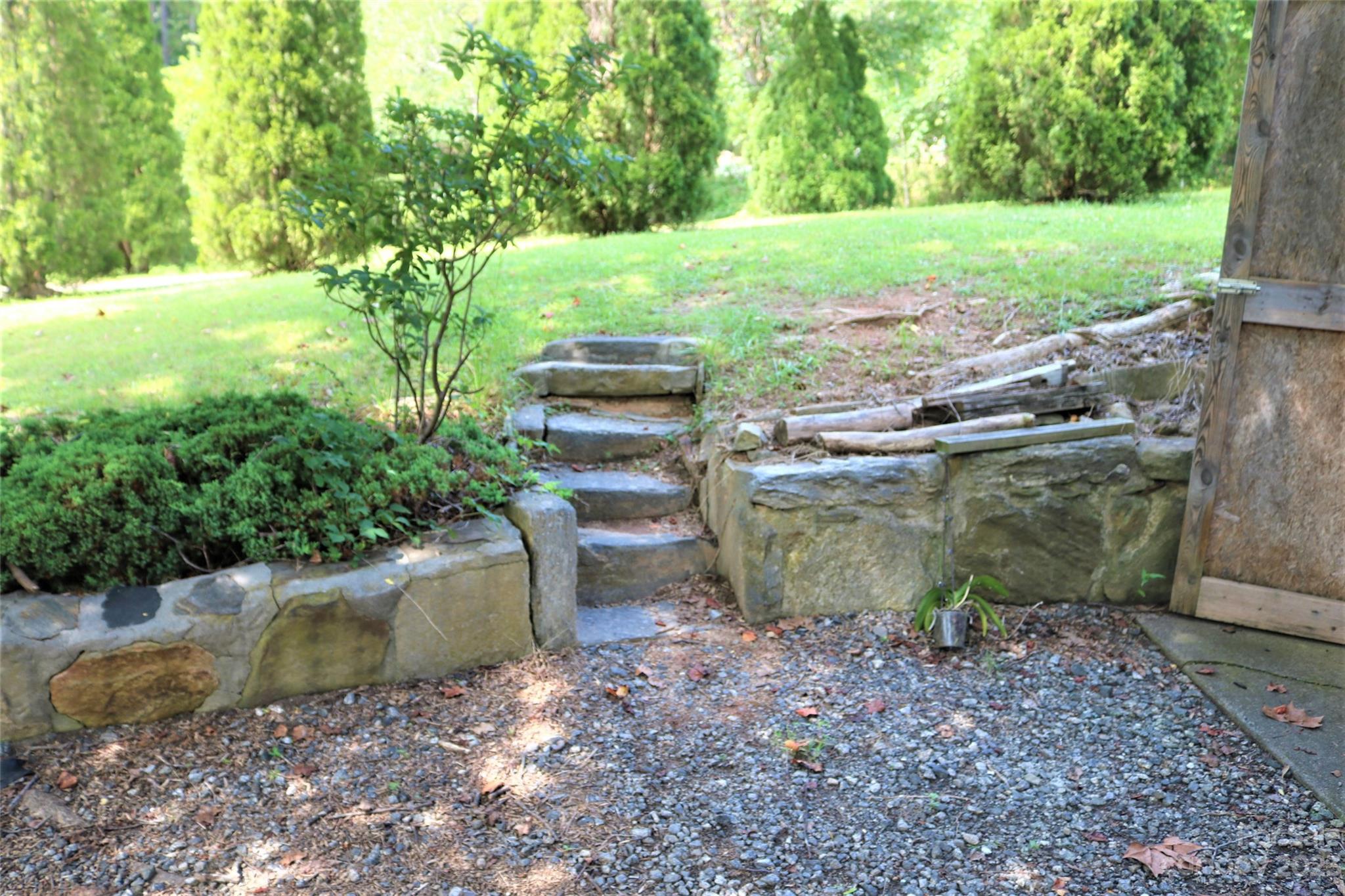 2919 Grassy Knob Road Mill Spring, NC 28756 - Photo 17 of 29 a view of a backyard with plants and lake