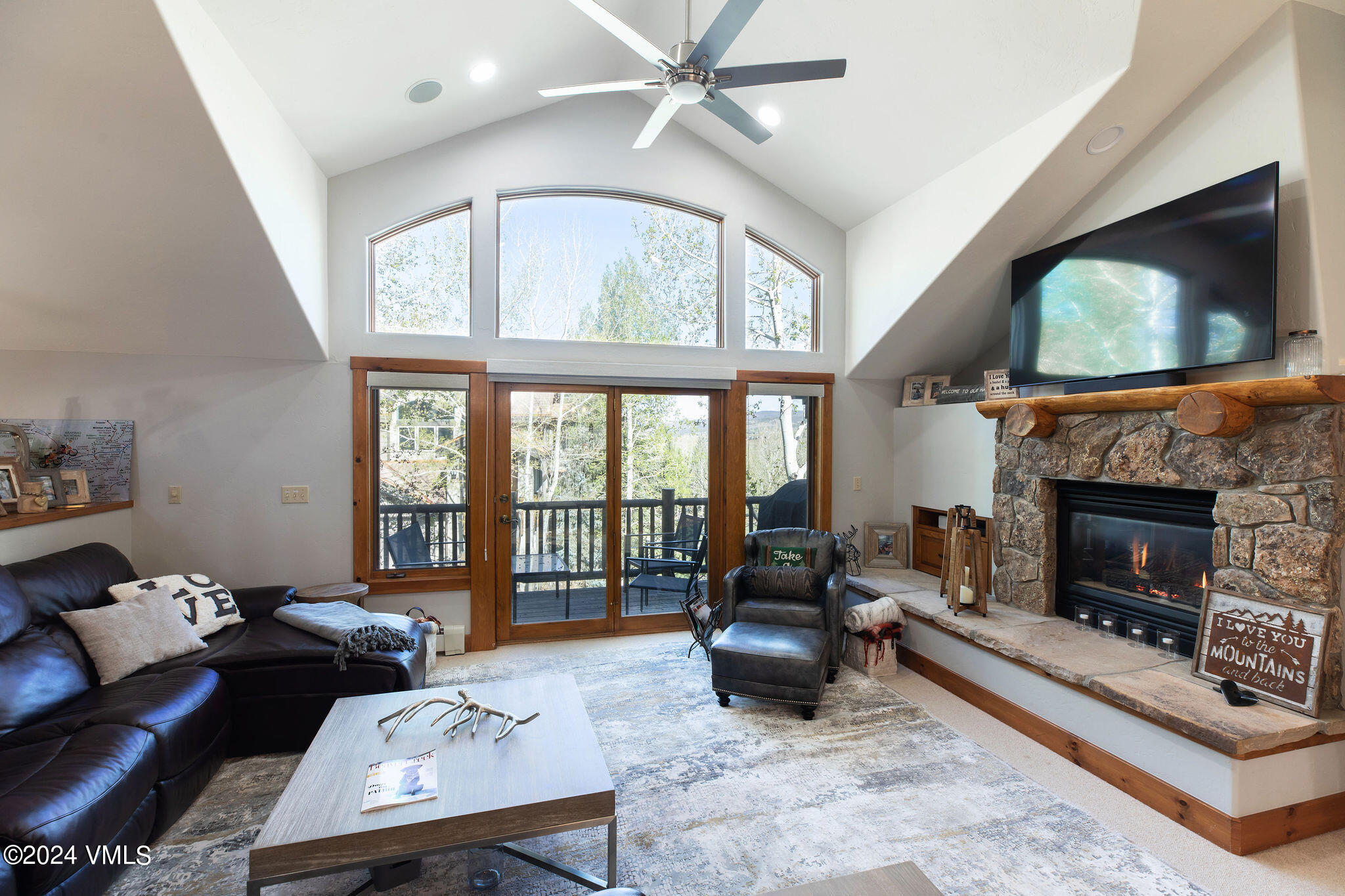 76 Knudson Ranch Road Edwards, CO 81632 - Photo 3 of 25 a living room with furniture a flat screen tv and a fireplace
