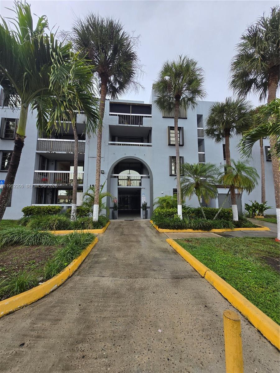 12219 Southwest 14th Lane, Unit 2110 Miami, FL 33184 - Photo 2 of 76 a front view of house with yard and green space