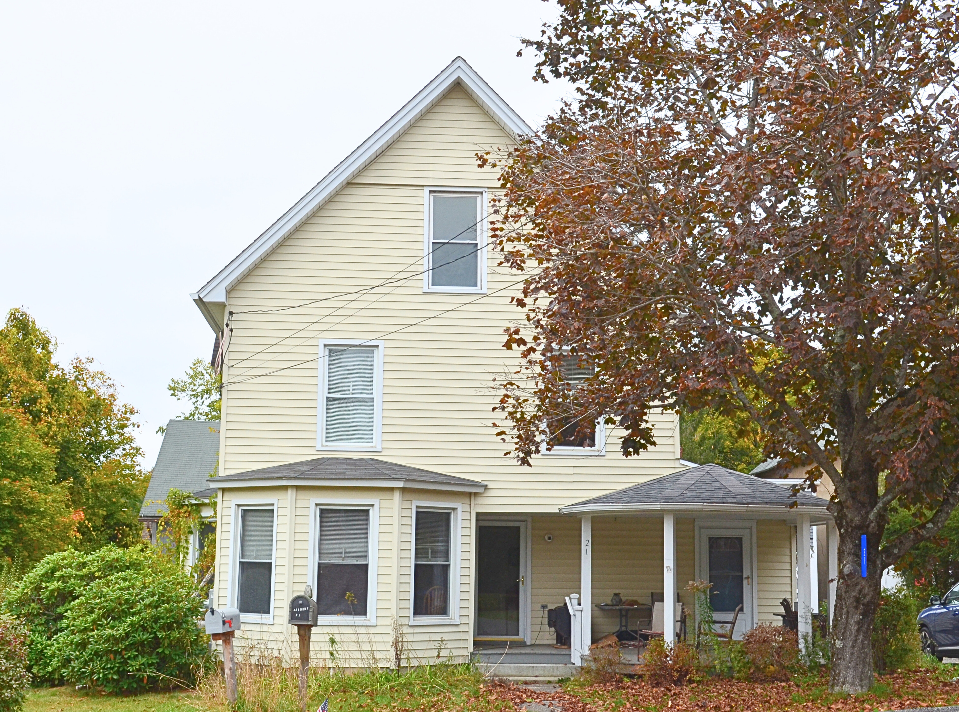 a view of a white house with large windows and a large tree
