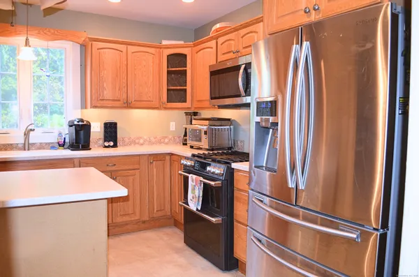 a kitchen with stainless steel appliances a refrigerator sink and microwave
