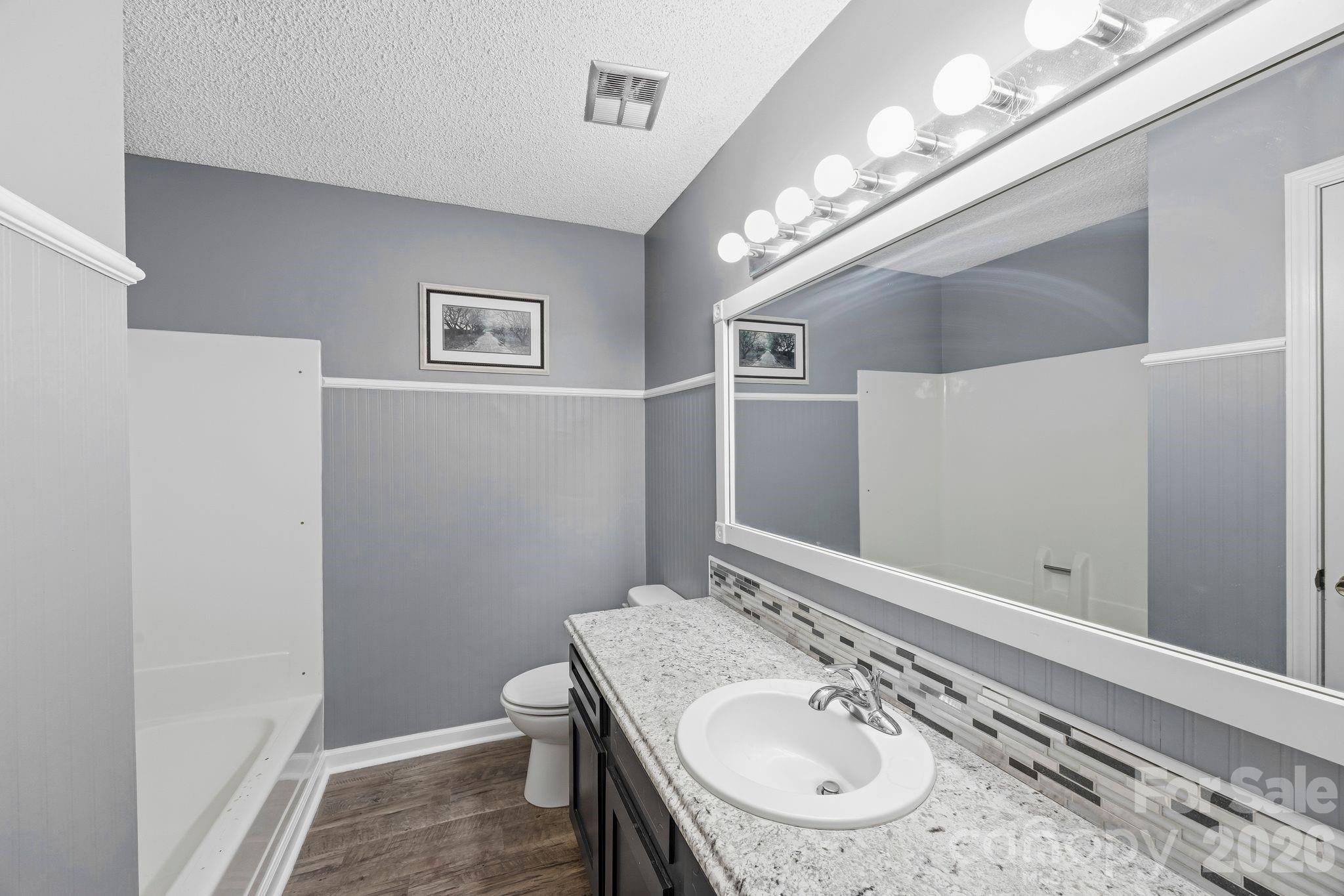 191 Fryling Avenue Southwest Concord, NC 28025 - Photo 15 of 25 a bathroom with a granite countertop sink a light fixture and a mirror