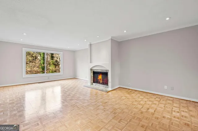 a view of an empty room with a window and fireplace