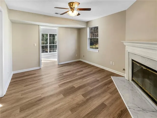 a view of empty room with wooden floor and fireplace