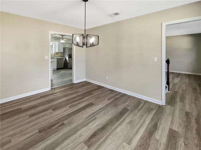 a view of empty room with wooden floor and ceiling fan