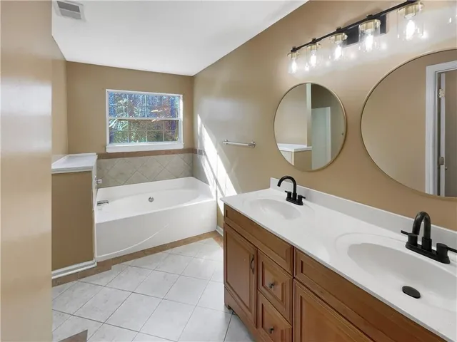 a bathroom with a tub sink and mirror