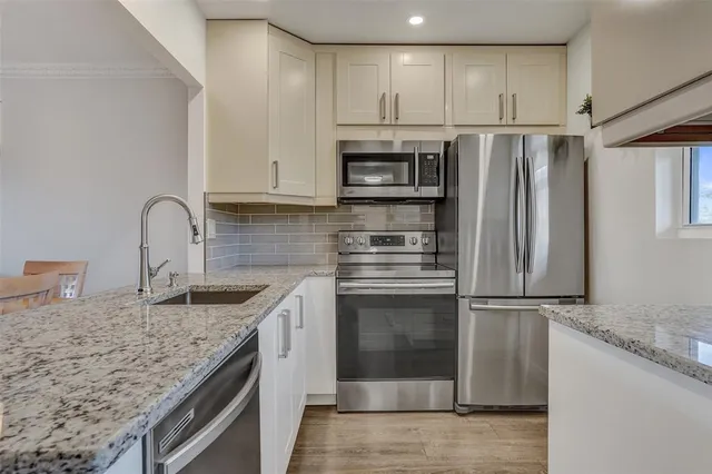 a kitchen with granite countertop a refrigerator and a sink