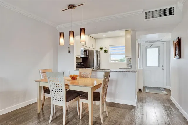 a dining room with furniture and a wooden floor