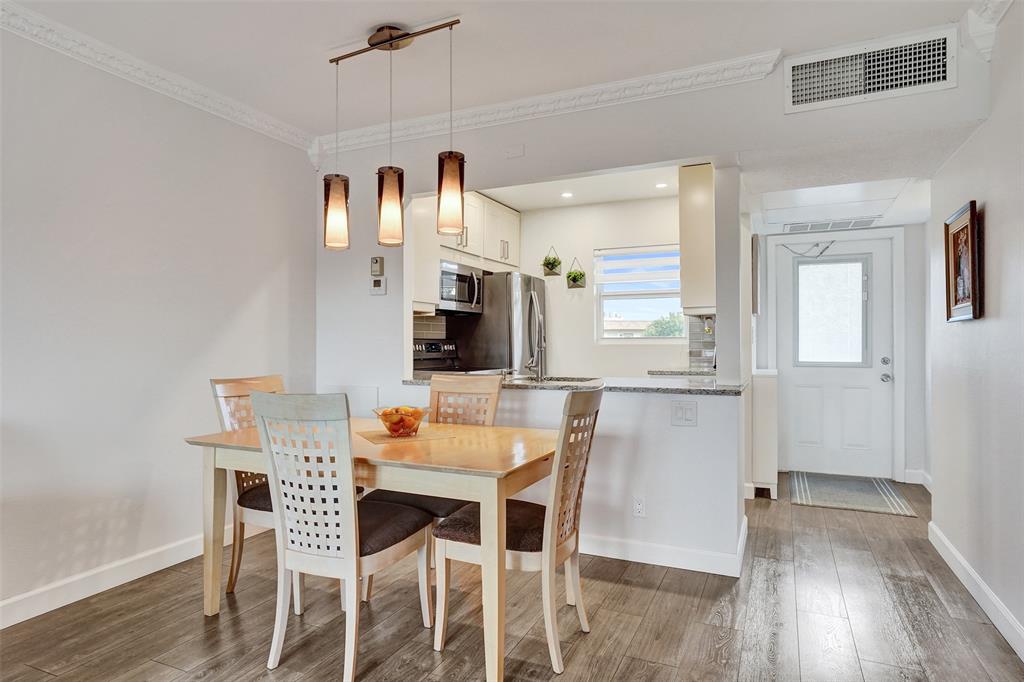 3405 Northwest 48th Avenue, Unit 611 Lauderdale Lakes, FL 33319 - Photo 3 of 34 a dining room with furniture and a wooden floor