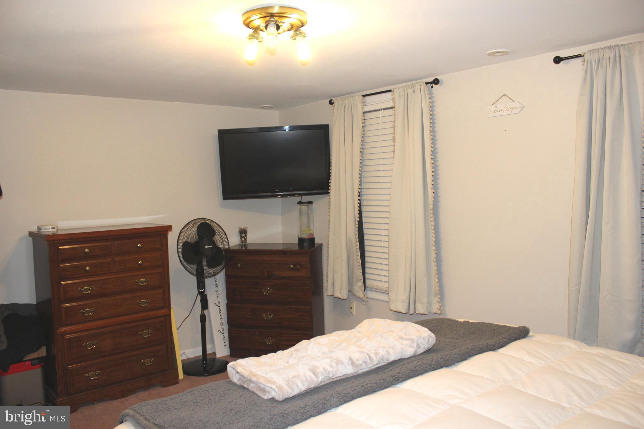 320 South Mill Street St. Clair, PA 17970 - Photo 30 of 37 a bedroom with a bed and a flat tv screen on a dresser