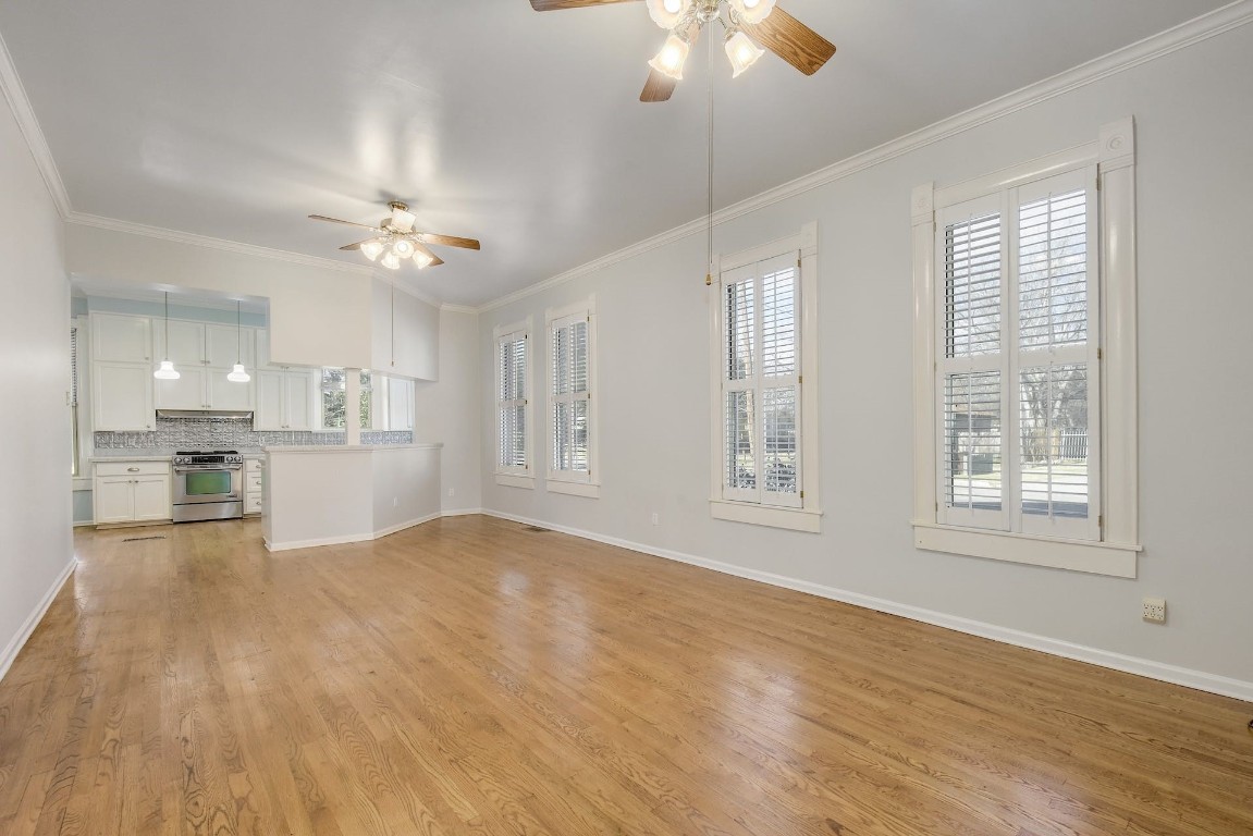 205 South Rio Grande Street Lockhart, TX 78644 - Photo 4 of 30 a view of an empty room with chandelier fan and wooden floor