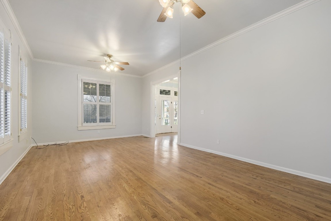 205 South Rio Grande Street Lockhart, TX 78644 - Photo 6 of 30 an empty room with wooden floor chandelier fan and windows