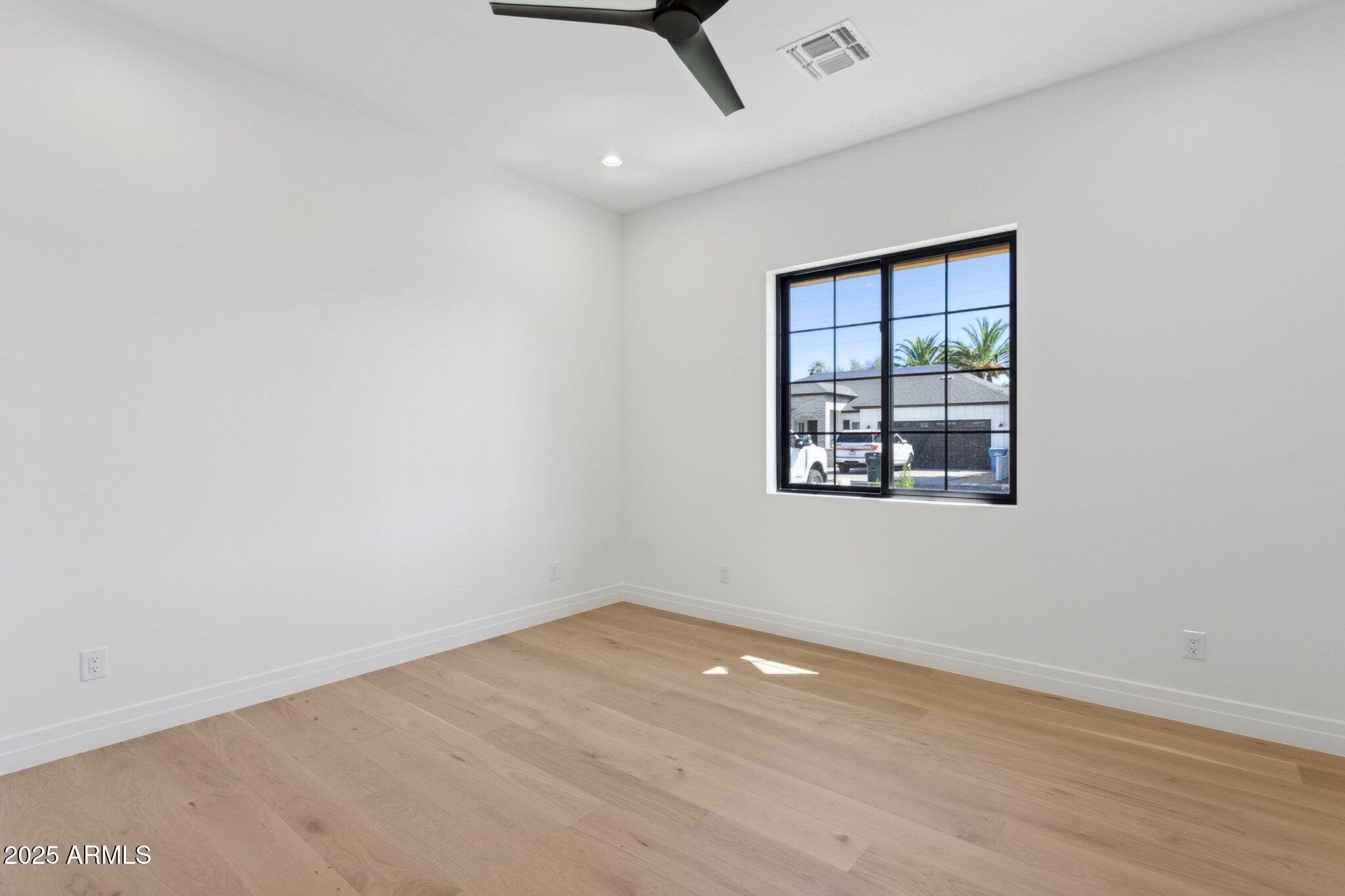 2942 North 47th Place Phoenix, AZ 85018 - Photo 33 of 40 an empty room with wooden floor and windows