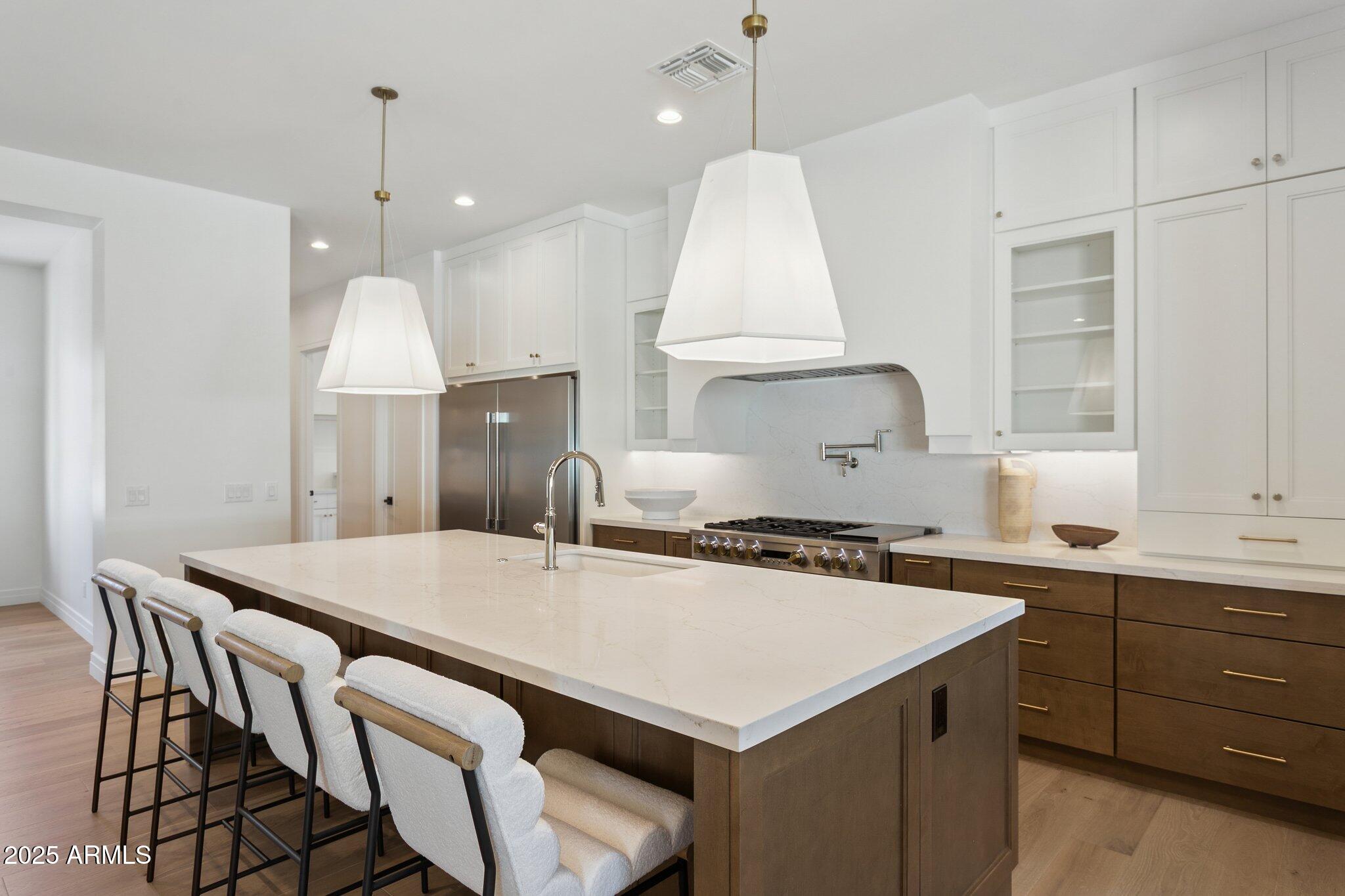 2942 North 47th Place Phoenix, AZ 85018 - Photo 6 of 40 a kitchen with a stove a sink a center island and a cabinets