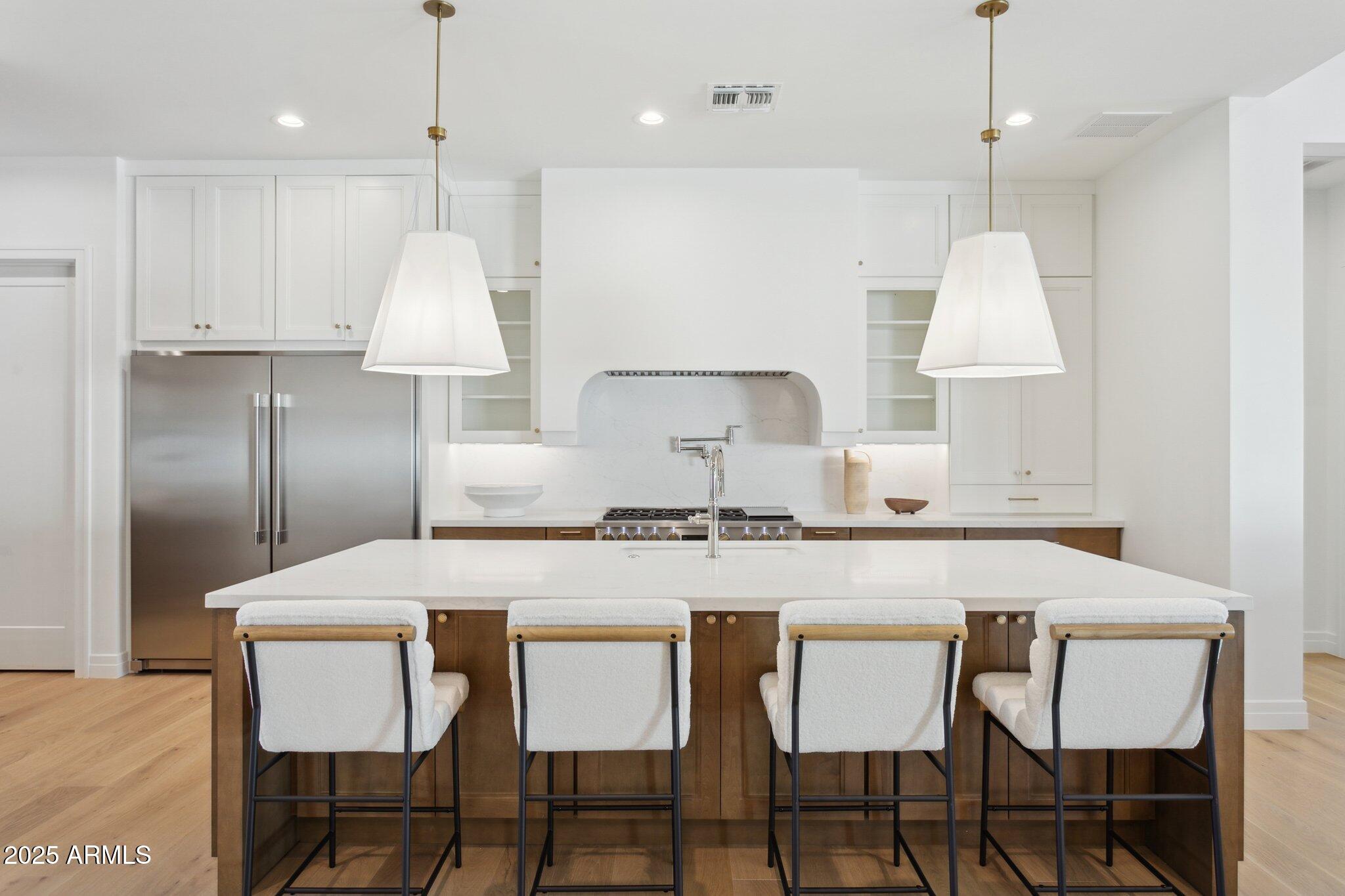 2942 North 47th Place Phoenix, AZ 85018 - Photo 7 of 40 a kitchen with granite countertop a table chairs stove a refrigerator and cabinets