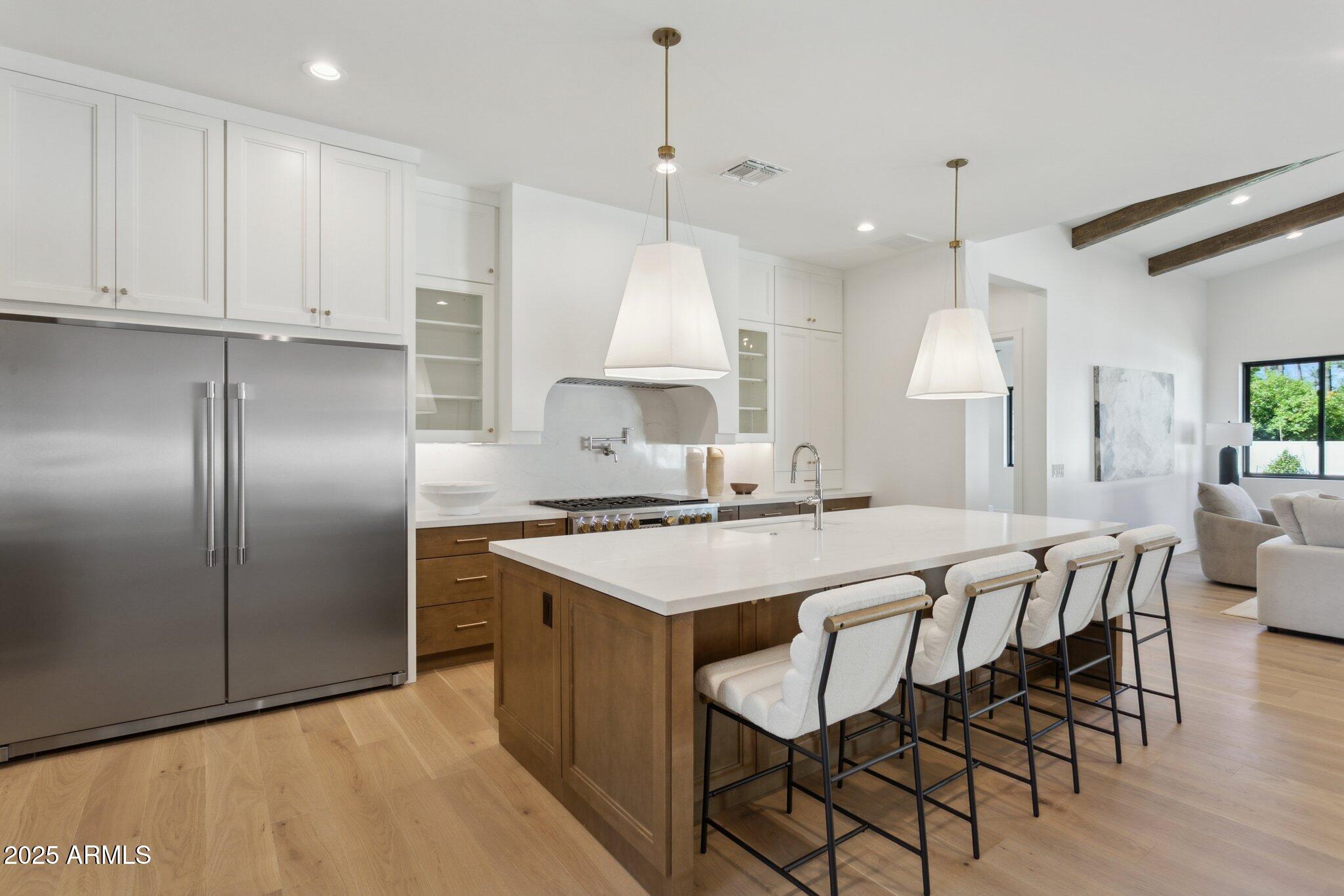 2942 North 47th Place Phoenix, AZ 85018 - Photo 8 of 40 a kitchen with stainless steel appliances granite countertop a stove a refrigerator a oven a sink with a dining table and chairs
