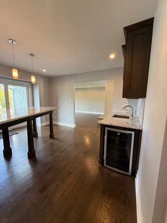 a view of an empty room with kitchen and a window