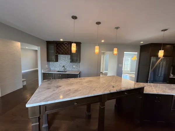 a kitchen with kitchen island a sink dishwasher a stove and a refrigerator with wooden floor