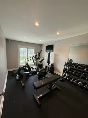 a room with gym equipment and a wooden floor