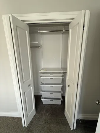a view of walk in closet with empty racks