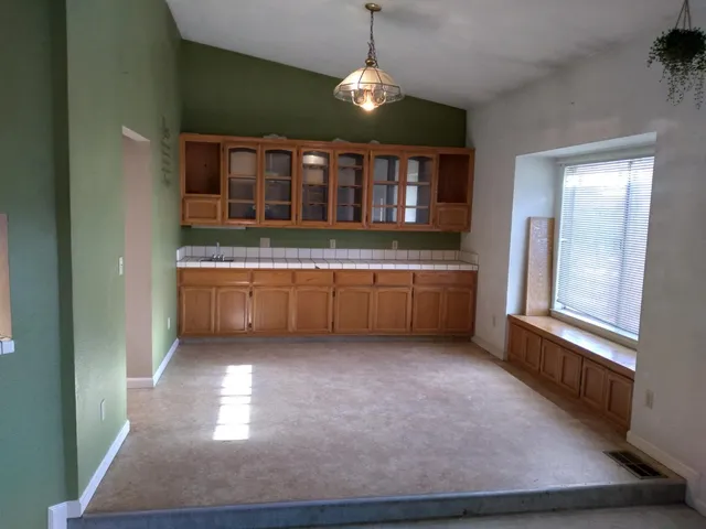 a living room with a large window and chandelier