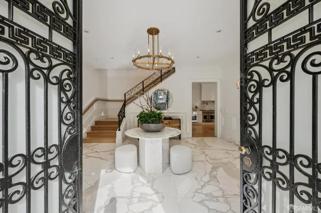 a living room with furniture a chandelier and a window