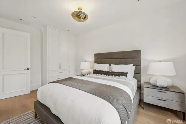 a living room with lots of white furniture and a painting on the wall