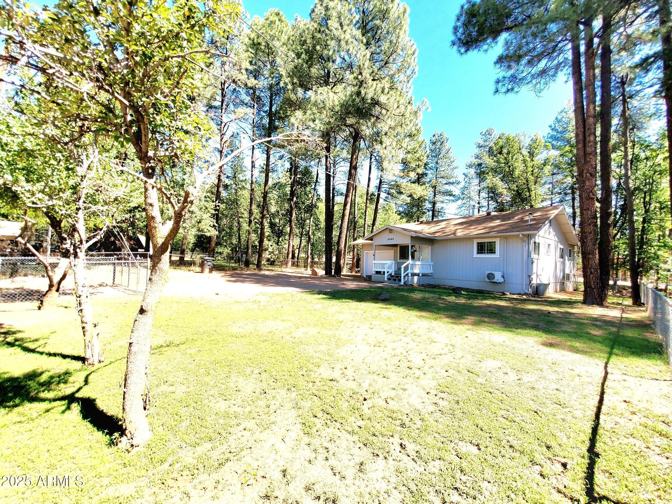 8449 Elk Road Pine, AZ 85544 - Photo 2 of 24 a view of swimming pool with large trees and wooden fence
