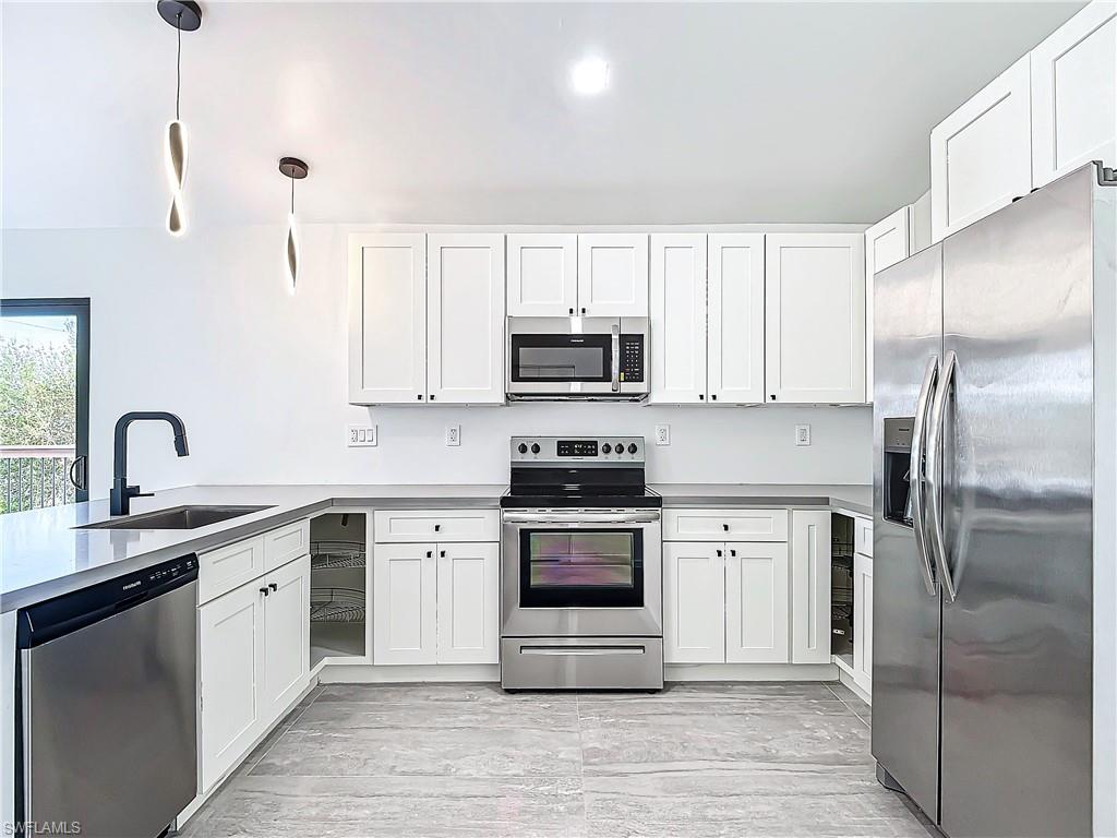 3710 10th Street Southwest Lehigh Acres, FL 33976 - Photo 11 of 30 a kitchen with stainless steel appliances granite countertop a stove a sink and a refrigerator