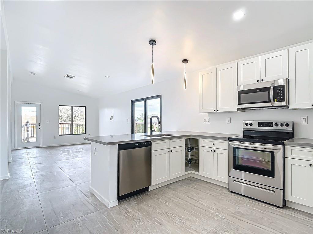 3710 10th Street Southwest Lehigh Acres, FL 33976 - Photo 12 of 30 a kitchen with stainless steel appliances granite countertop a stove a sink and a microwave