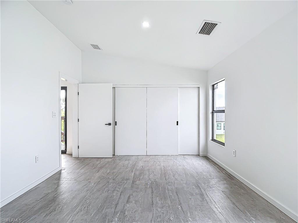 3710 10th Street Southwest Lehigh Acres, FL 33976 - Photo 16 of 30 an empty room with window and wooden floor