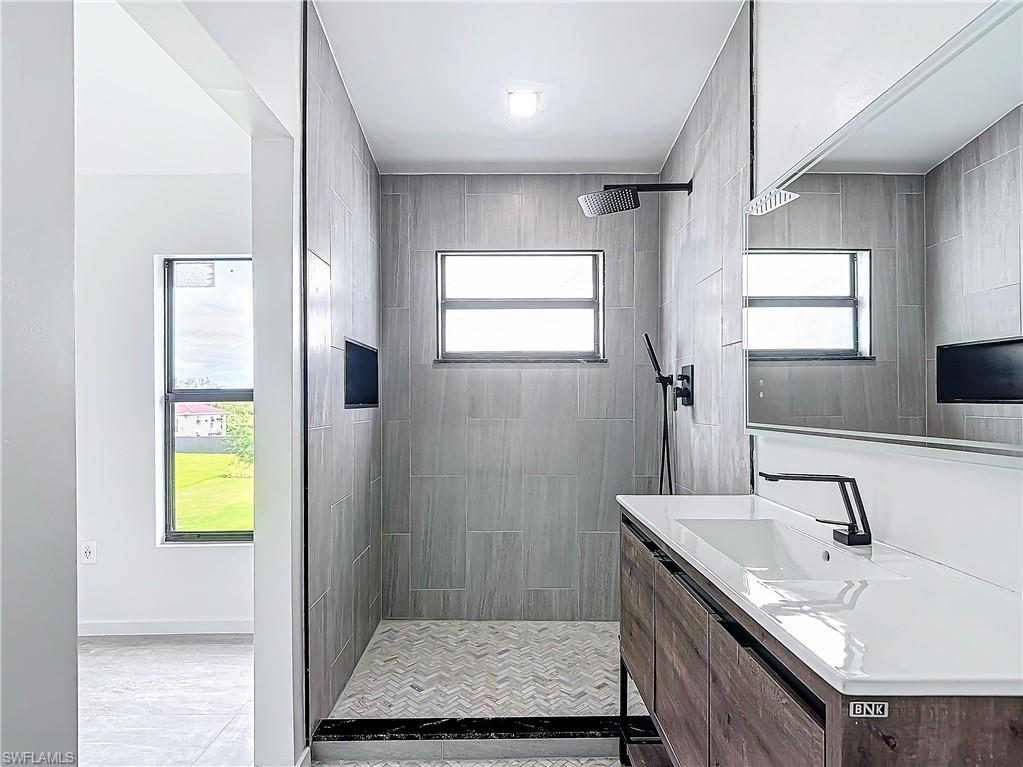 3710 10th Street Southwest Lehigh Acres, FL 33976 - Photo 20 of 30 a bathroom with a granite countertop sink a mirror and a shower