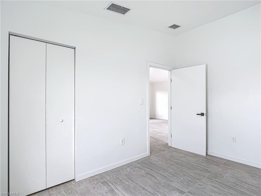 3710 10th Street Southwest Lehigh Acres, FL 33976 - Photo 24 of 30 a view of an empty room with wooden floor