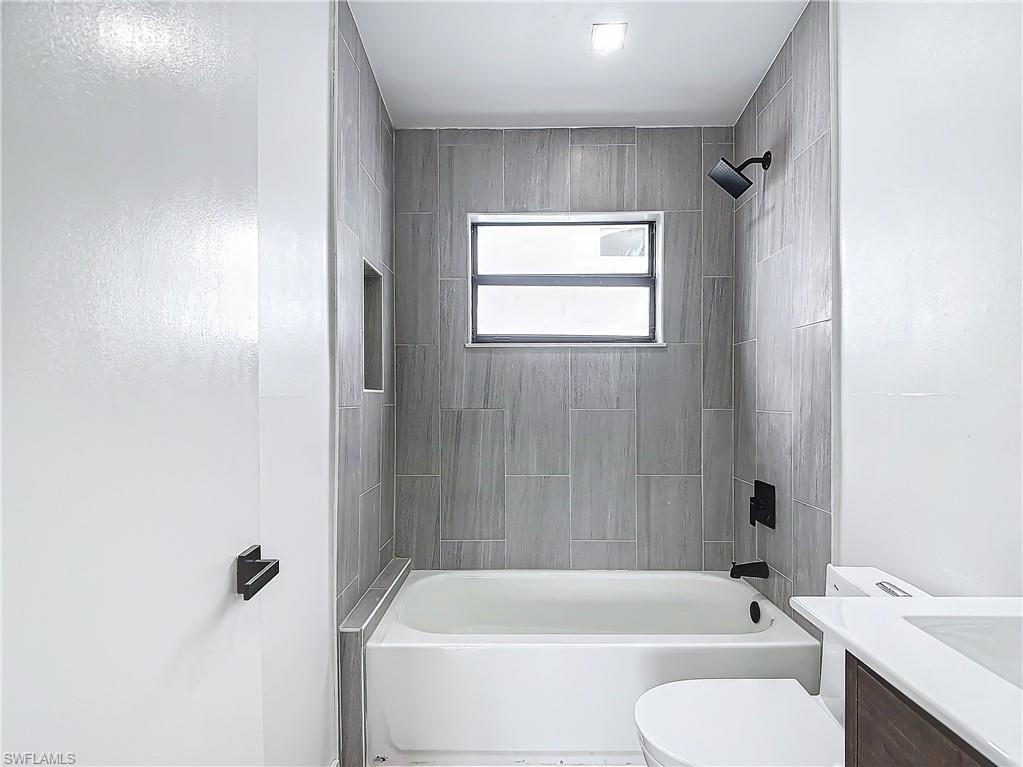 3710 10th Street Southwest Lehigh Acres, FL 33976 - Photo 26 of 30 a bathroom with a tub shower sink and a toilet