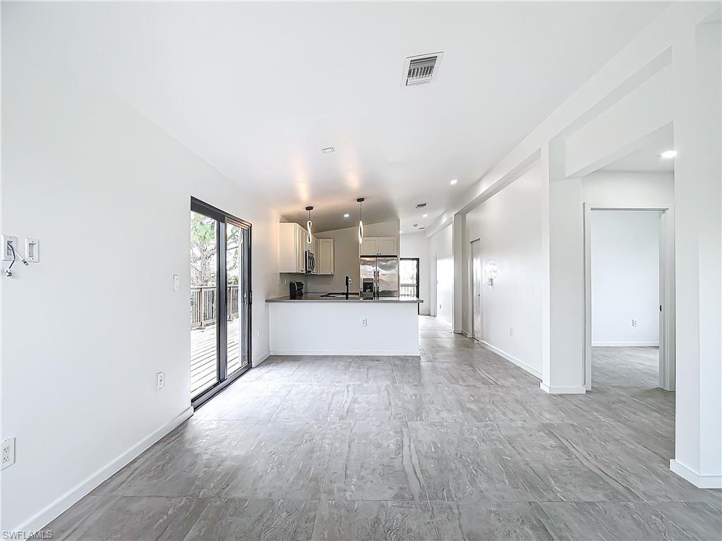 3710 10th Street Southwest Lehigh Acres, FL 33976 - Photo 4 of 30 a view of a hallway with wooden floor and a living room