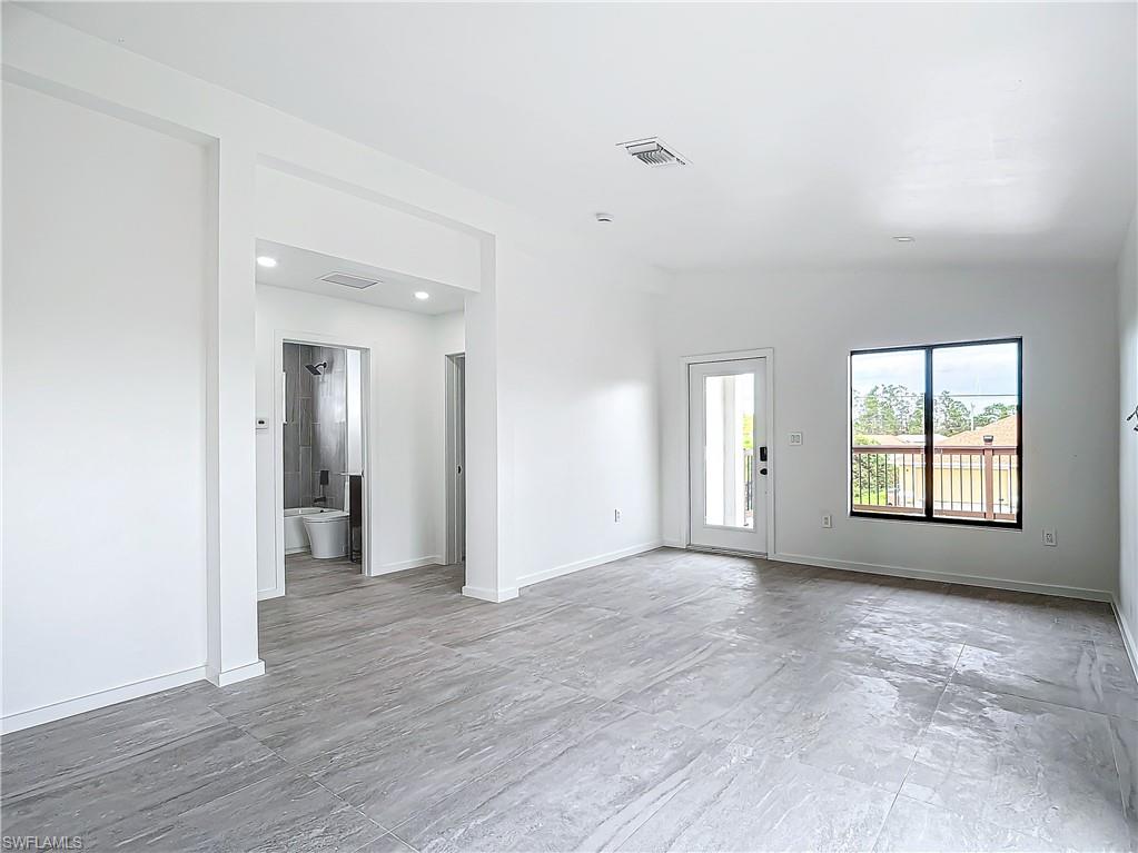 3710 10th Street Southwest Lehigh Acres, FL 33976 - Photo 8 of 30 an empty room with wooden floor and windows