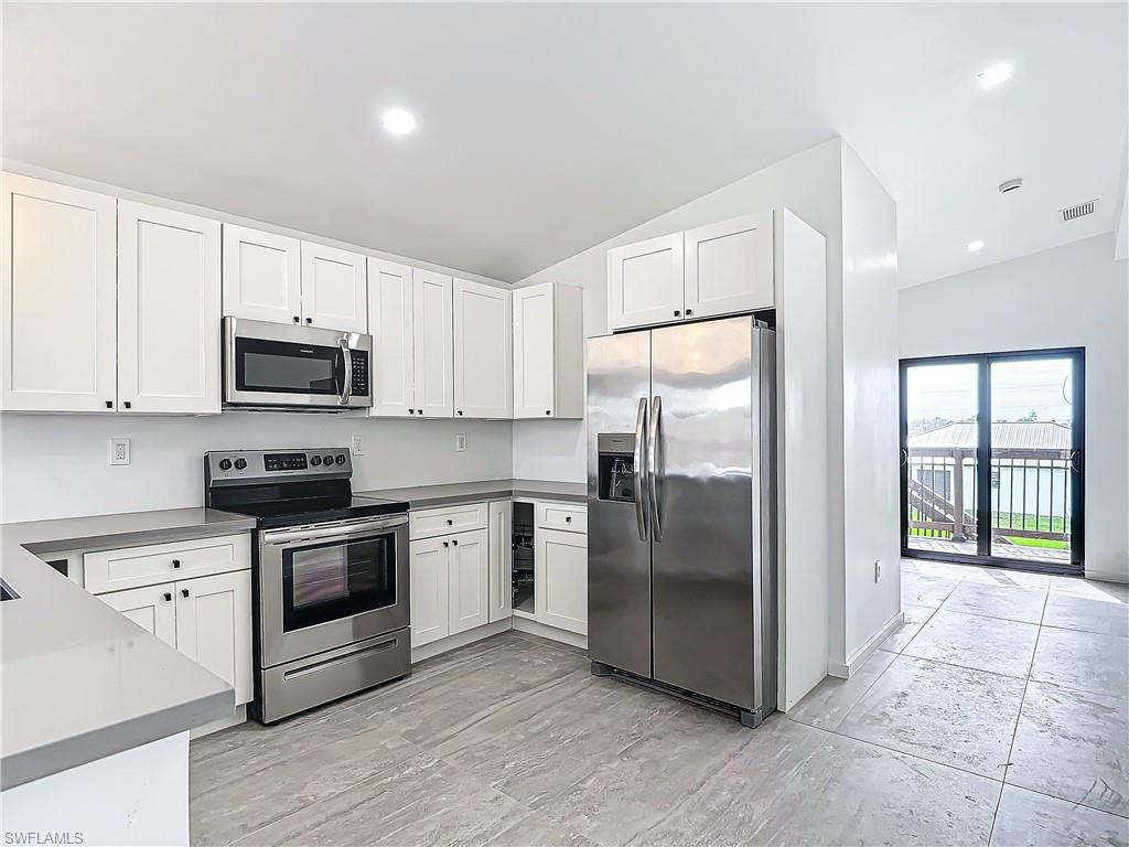 3710 10th Street Southwest Lehigh Acres, FL 33976 - Photo 10 of 30 a kitchen with granite countertop a refrigerator and a stove top oven