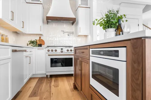 a kitchen with white cabinets and white appliances