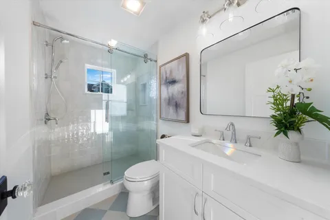 a bathroom with a sink a toilet and shower