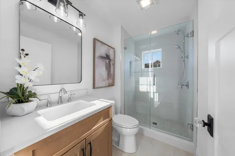 a bathroom with a sink a toilet and shower