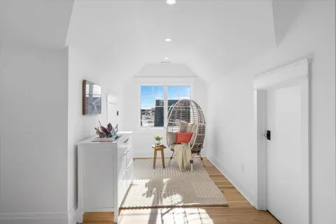 a view of a hallway with a dining room and furniture