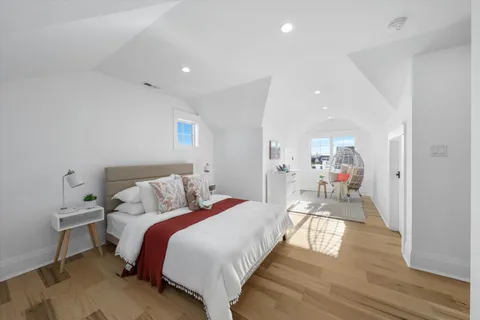 a bed room with a bed and a view of kitchen