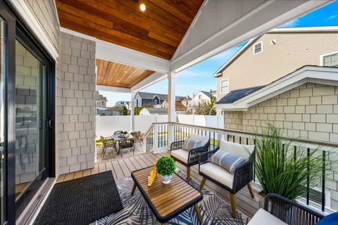 a balcony with wooden floor and outdoor seating