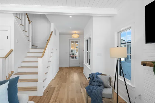 a view of a hallway with furniture and wooden floor