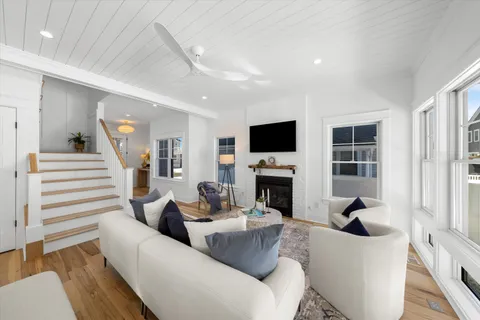 a living room with furniture a fireplace and a flat screen tv