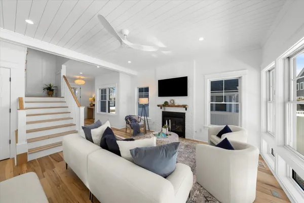 a living room with furniture a fireplace and a flat screen tv