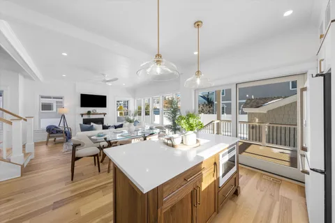a view of a dining room and livingroom with furniture wooden floor a chandelier